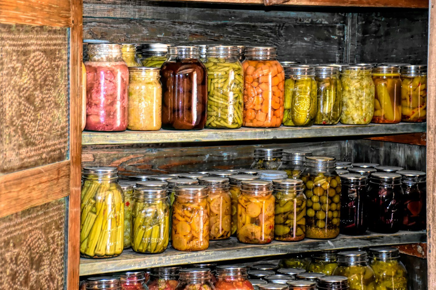 Glass jars of preserved food on wooden shelves